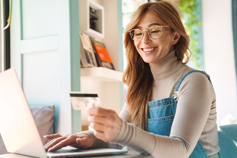 lady paying on computer with debit card